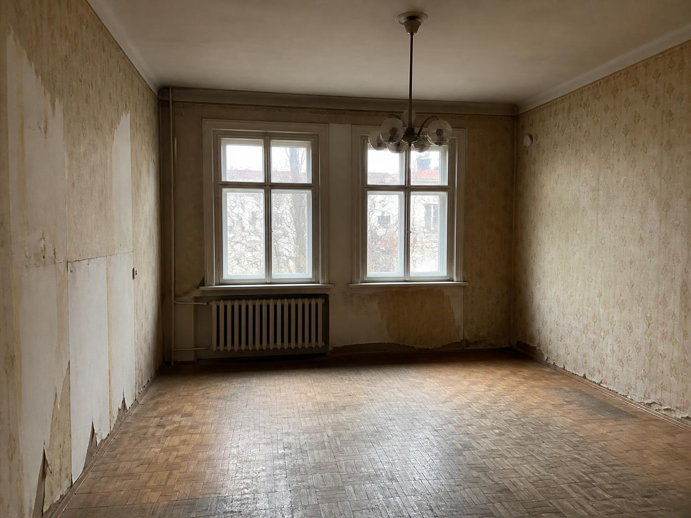 Salon przed remontem — stara tapeta i zniszczony parkiet